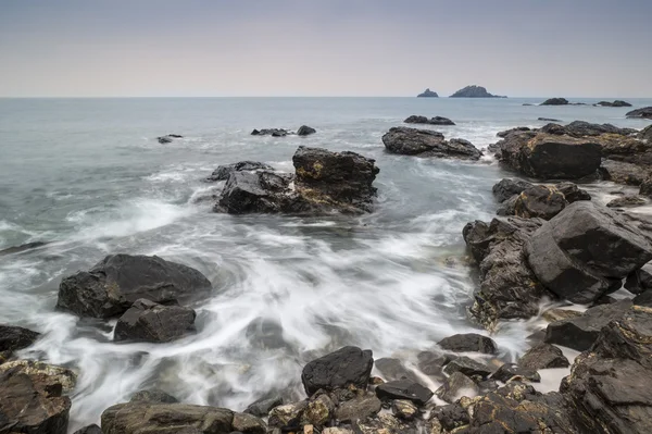 Rocky shore and Brisons Rock in distance at Cape Cornwall — Stock Photo, Image