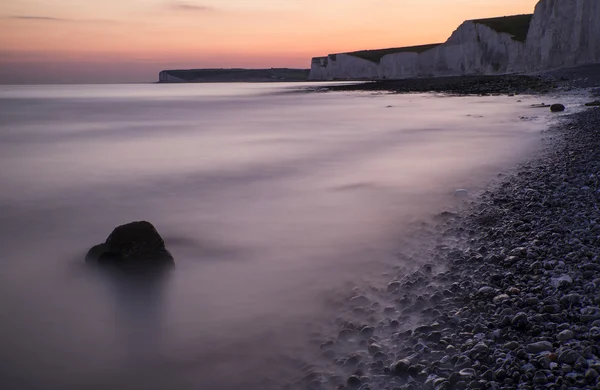 Lunga esposizione paesaggio roccioso litorale al tramonto — Foto Stock