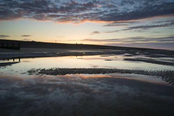 Levendige zonsopgang landschap weerspiegeld in low tide water op strand — Stockfoto