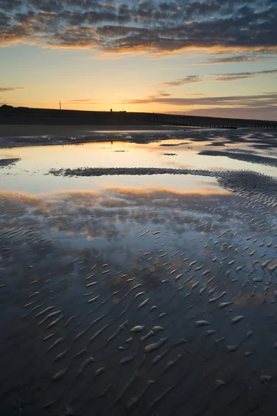 Vibrant sunrise landscape reflected in low tide water on beach — Stock Photo, Image