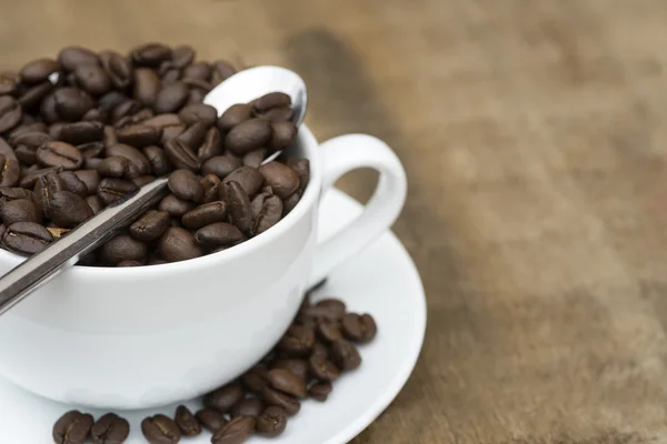 Cup of coffee and beans on wooden background — Stock Photo, Image