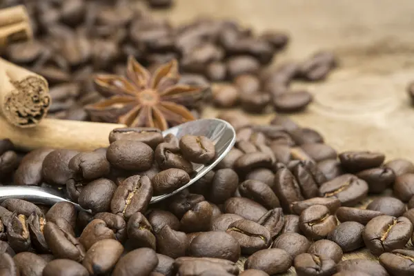 Coffee beans and spoon on wooden background — Stock Photo, Image