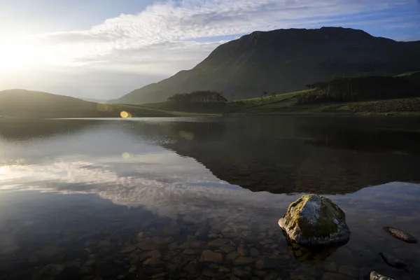 Schöne Berglandschaft im Sonnenaufgang spiegelt sich in ruhigem See wider — Stockfoto