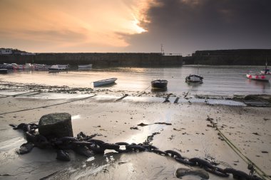 A traditional Cornish fishing village at sunrise in Cornwall England clipart