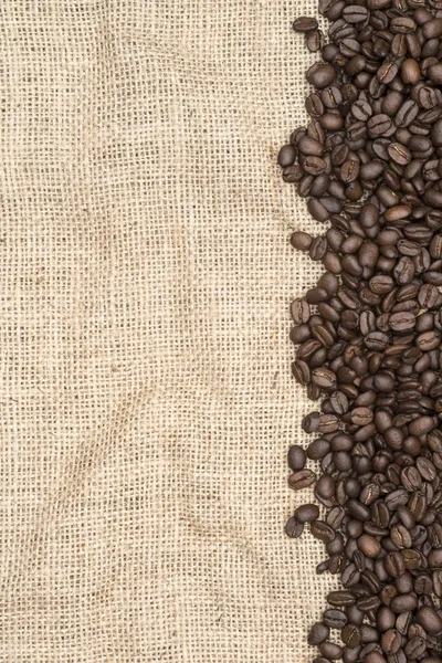 Coffee beans on hessian background — Stock Photo, Image