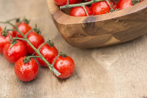 Fresh cherry tomatoes in rustic vintage wooden bowl — Stock Photo, Image
