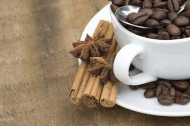 Tahta arka planda bir fincan kahve ve fasulye.