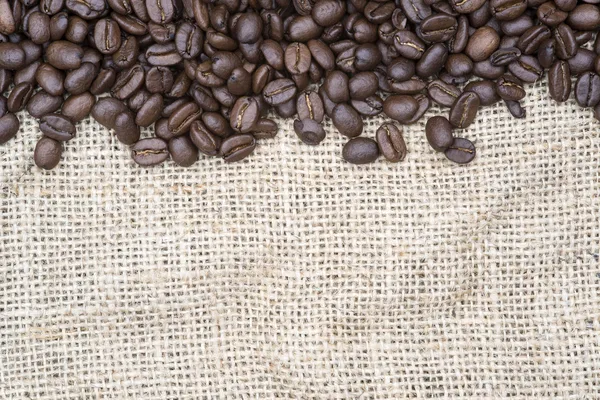 Coffee beans on hessian background — Stock Photo, Image