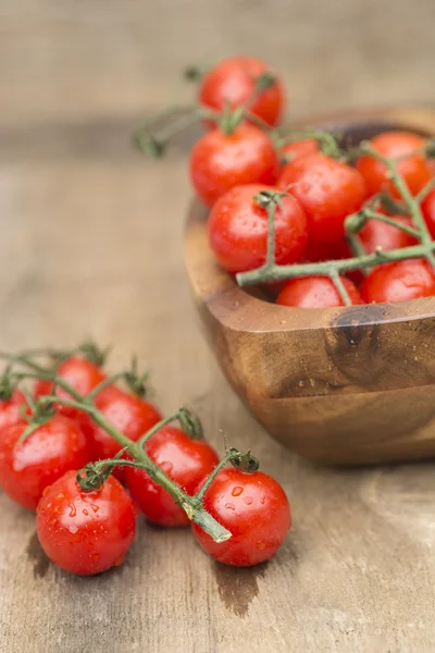 Fresh cherry tomatoes in rustic vintage wooden bowl — Stock Photo, Image