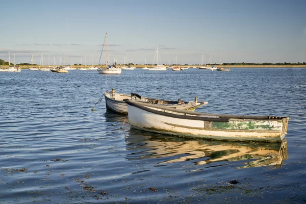 Velhos barcos de pesca refletidos em água calma durante o pôr do sol de verão — Fotografia de Stock