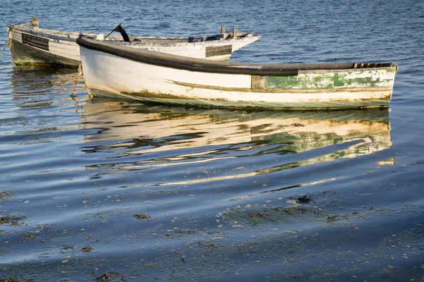 Antiguos barcos de pesca reflejados en aguas tranquilas durante el atardecer de verano —  Fotos de Stock