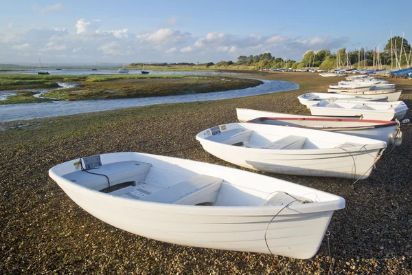 Pequeños barcos de recreo amarrados en marea baja en puerto deportivo al atardecer de verano — Foto de Stock