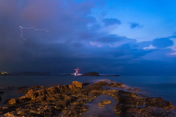 Stunning landscape with storm and lightning dawn with rocky coas