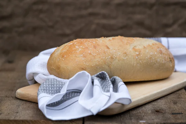 Bochník kváskový chleba v rustikální kitchend prostředí — Stock fotografie