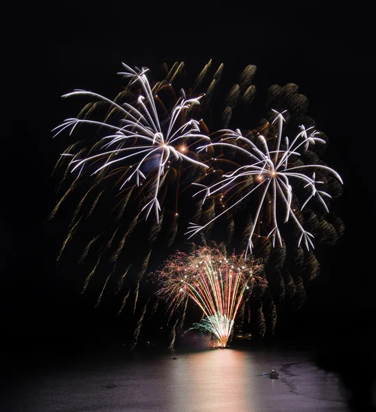 Vuurwerk over zee met reflecties in water — Stockfoto