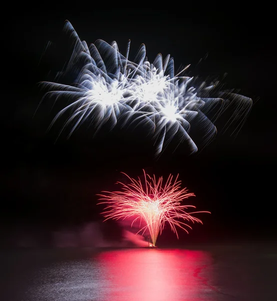 Fireworks display over sea with reflections in water — Stock Photo, Image