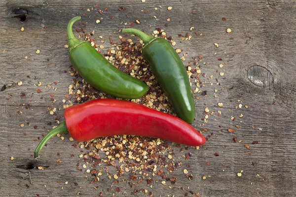 Red cayenne and green chili peppers on wooden background — Stock Photo, Image