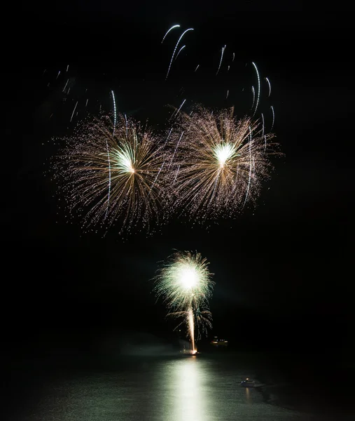 Fireworks display over sea with reflections in water — Stock Photo, Image
