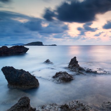 Stunning landscapedawn sunrise with rocky coastline and long exp