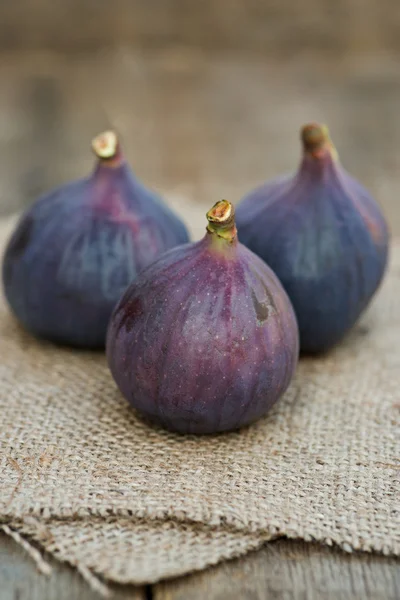 Fresh figs on hessian napkins on wooden background — Stock Photo, Image