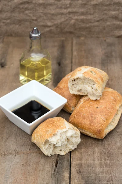 Olive bread rollis in rustic kitchen setting with utensils — Stock Photo, Image