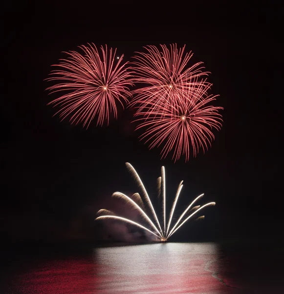 Vuurwerk over zee met reflecties in water — Stockfoto