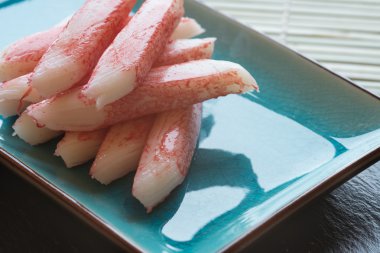 verse rauwe sushi crabsticks op plaat met stokjes
