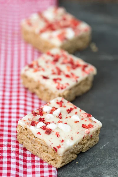 Strawberry and meringue topped flapjack on gingham cloth — Stock Photo, Image