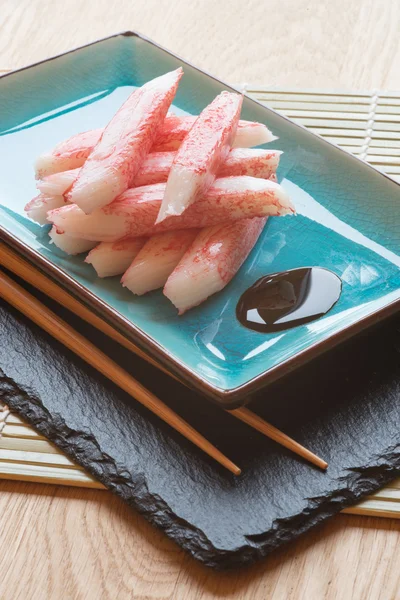 Fresh raw sushi crabsticks on plate with chopsticks — Stock Photo, Image