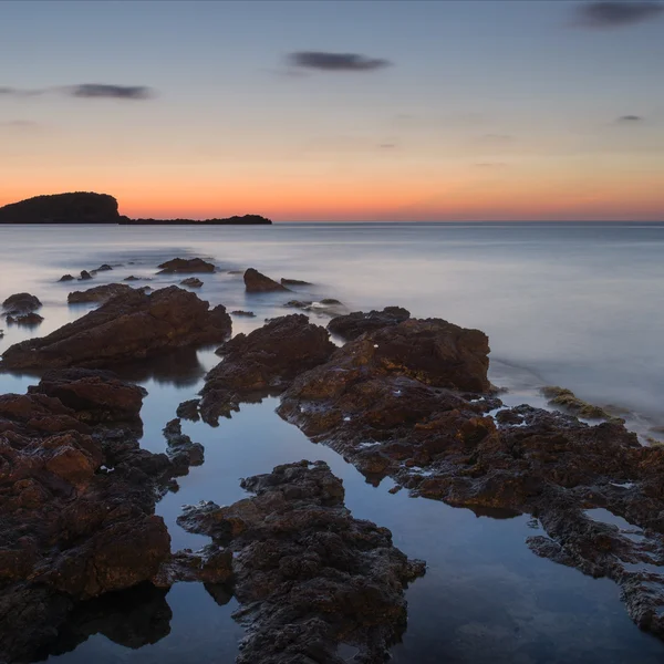 Landscape seascape of jagged and rugged rocks on coastline with — Stock Photo, Image