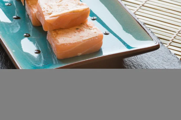 Paquetes de queso crema de salmón de sushi fresco en plato con palillos — Foto de Stock