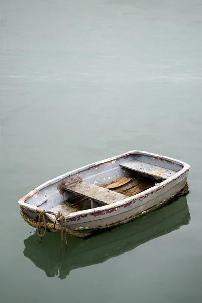 Забытая старая лодка на спокойной морской воде — стоковое фото