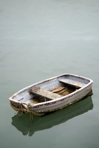 Neglected old rowing boat on calm sea water — Stock Photo, Image