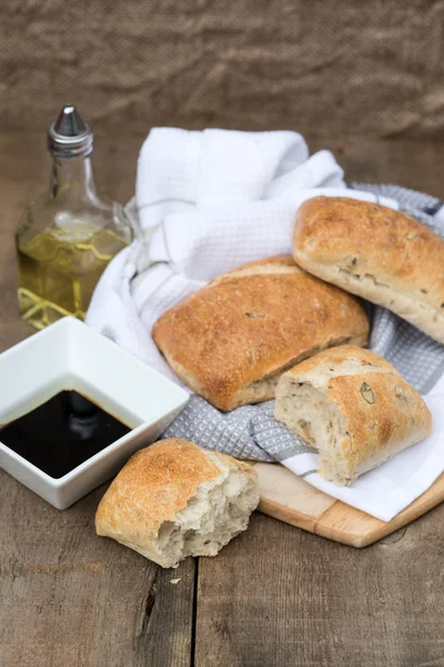 Oliv bröd rollis i rustika köket inställningen med köksredskap — Stockfoto