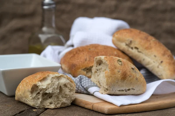 Olijf brood rollis in rustieke keuken instelling met keukengerei — Stockfoto
