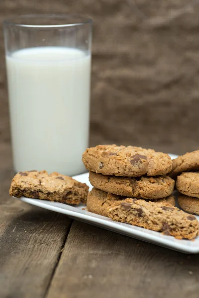 Rustik miljö med chocolate chip cookies och glas mjölk — Stockfoto