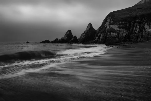 Landscape seascape of jagged and rugged rocks on coastline with — Stock Photo, Image