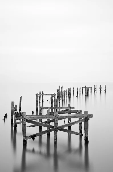 Fine art landschap foto van braakliggende pier in melkachtig lange blootstelling — Stockfoto