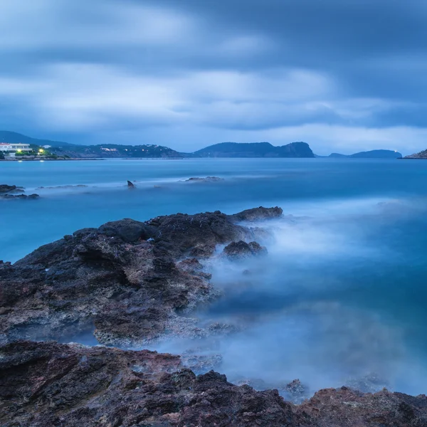 Stunning landscape at twilight dawn with rocky coastline and lon — Stock Photo, Image