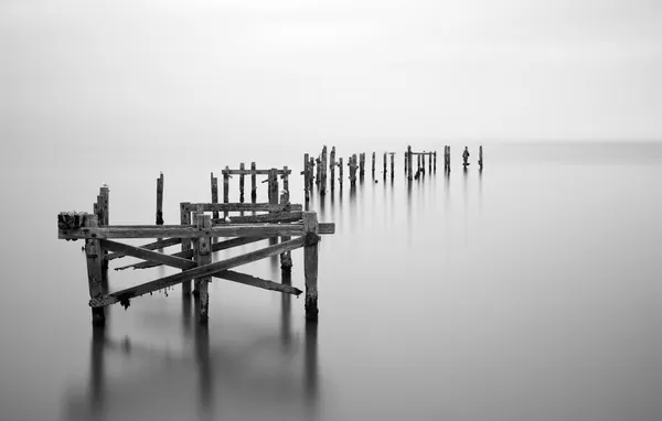 Fine art landschap foto van braakliggende pier in melkachtig lange blootstelling — Stockfoto