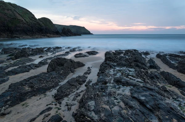 Hoop cove zonsondergang landschap zeegezicht met rotsachtige kustlijn en lon — Stockfoto