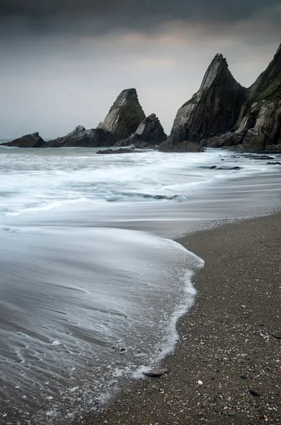 Landscape seascape of jagged and rugged rocks on coastline with — Stock Photo, Image