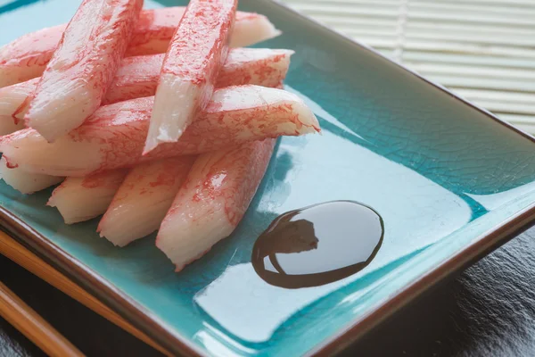 Fresh raw sushi crabsticks on plate with chopsticks — Stock Photo, Image