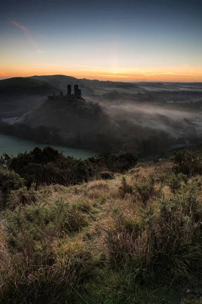 Středověký hrad trosky s zamlžené krajiny při východu slunce — Stock fotografie