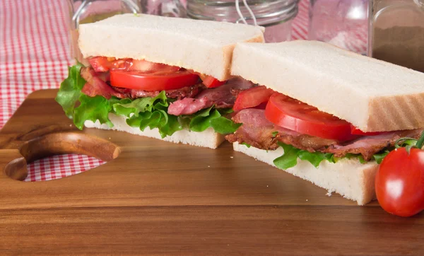 Свіжий BLT на білому сендвічі в сільській обстановці кухні — стокове фото