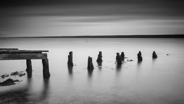 Long exposure landscape of old derelict jetty extending into lak — Stock Photo, Image