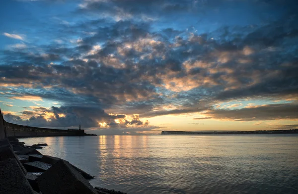 Céu de nascer do sol vibrante bonito sobre oceano de água calma com lightho — Fotografia de Stock