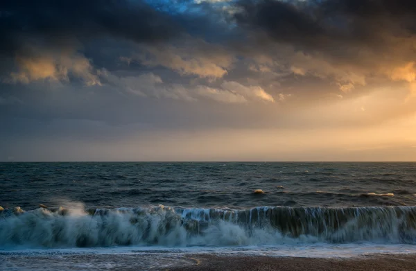 Hermoso atardecer de invierno sobre olas rompiendo en la playa —  Fotos de Stock