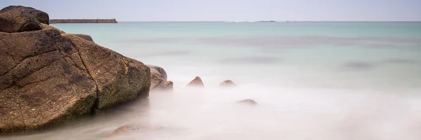 Paisagem de exposição longa panorama de rochas na praia na maré baixa — Fotografia de Stock