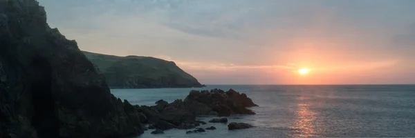 Panorama landscape vibrant sunset over rocky coastline — Stock Photo, Image